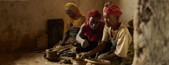 Three women making ceramic pots in Rwanda