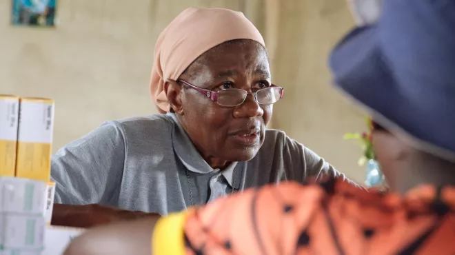 Sister Martine，a trained nurse，dispensing medicine at the Catholic mission’s health center in Ntui，Cameroon。