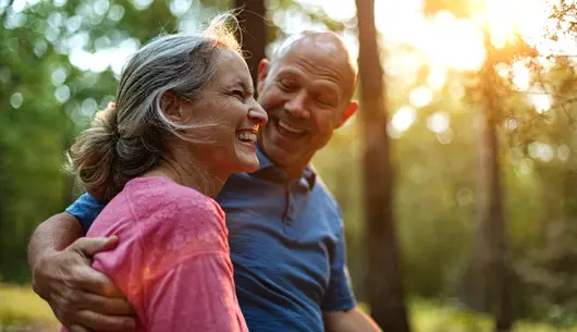 Two people embracing in a wooded area