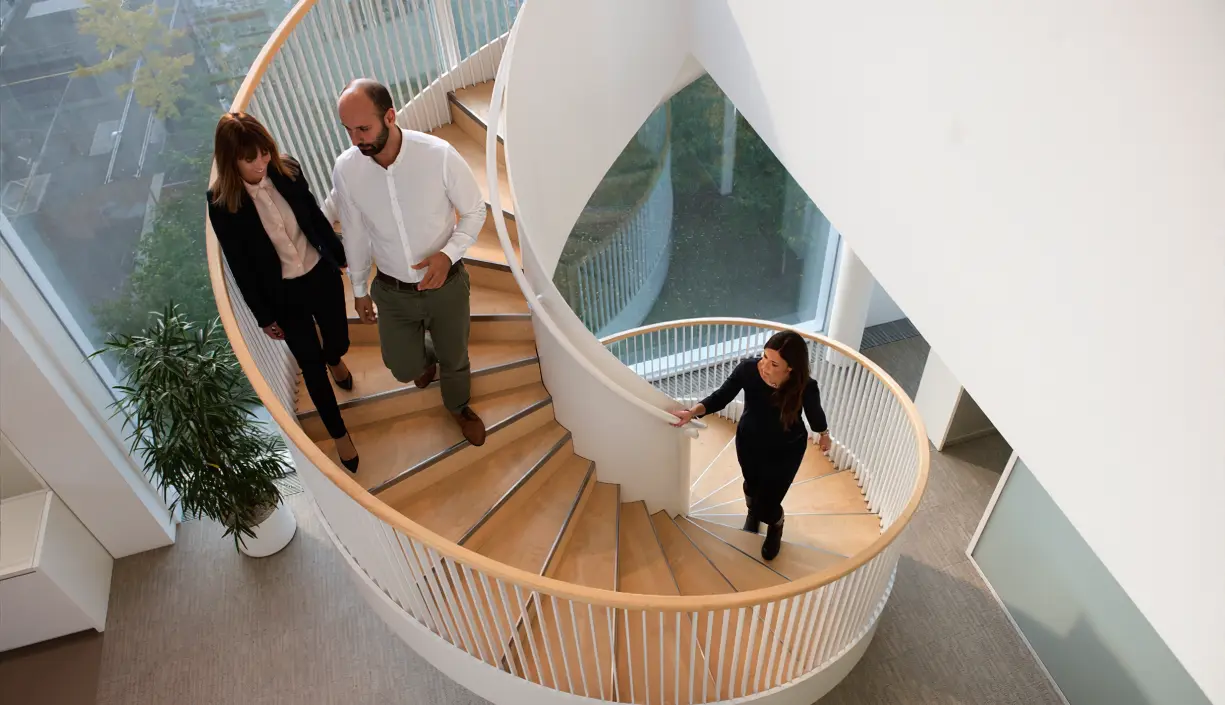 Professionals walking on a spiral staircase in an office building
