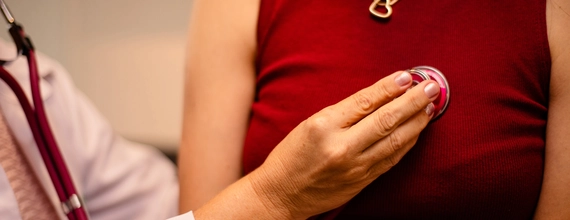 Doctor examining heartbeat with stethoscope on patient's chest