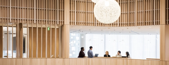 Modern wooden reception area with people having a discussion
