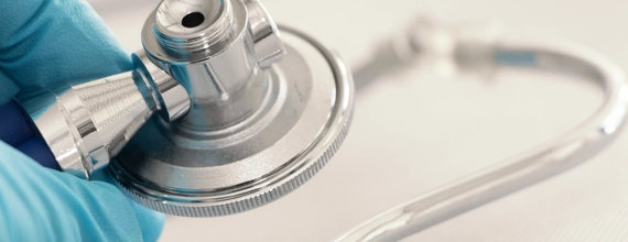 Stethoscope and healthcare professional's hand in medical setting