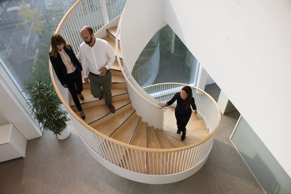 People on spiral staircase in modern office building