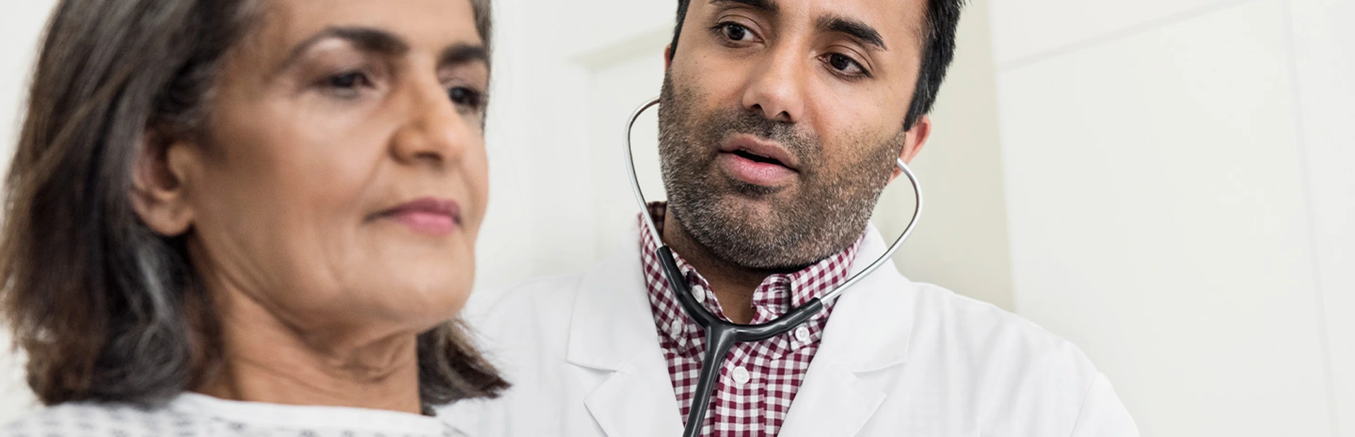 Ein Arzt untersucht eine Herzinsuffizienz-Patientin im Krankenhaus