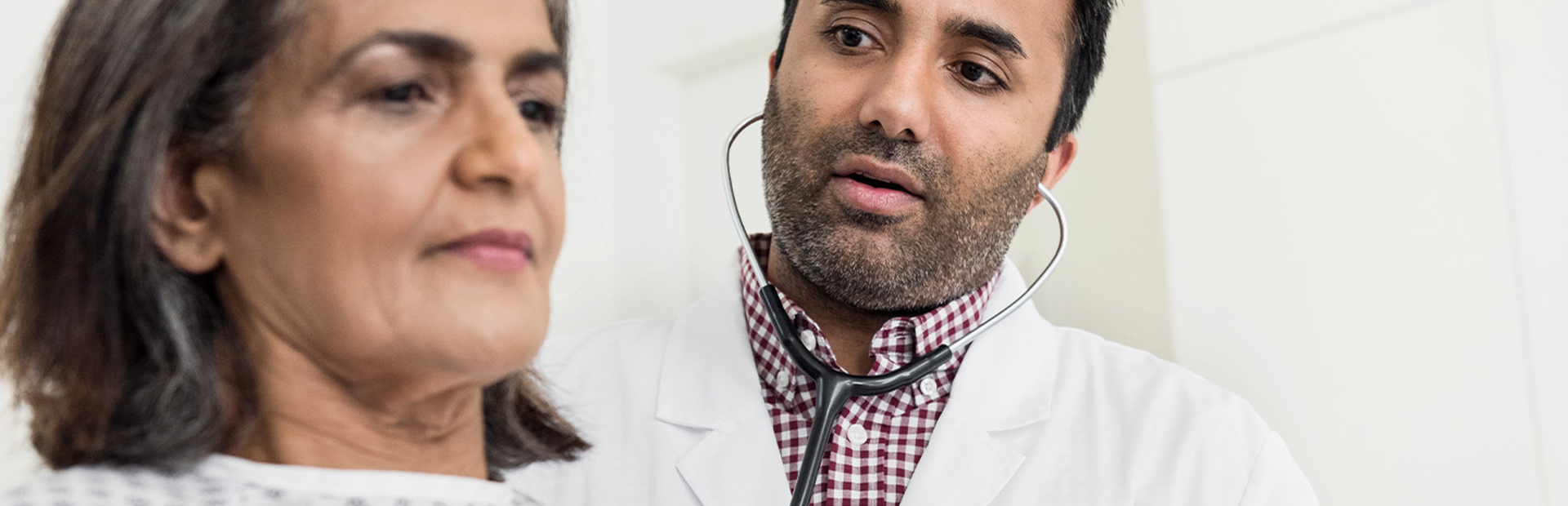 Ein Arzt untersucht eine Herzinsuffizienz-Patientin im Krankenhaus
