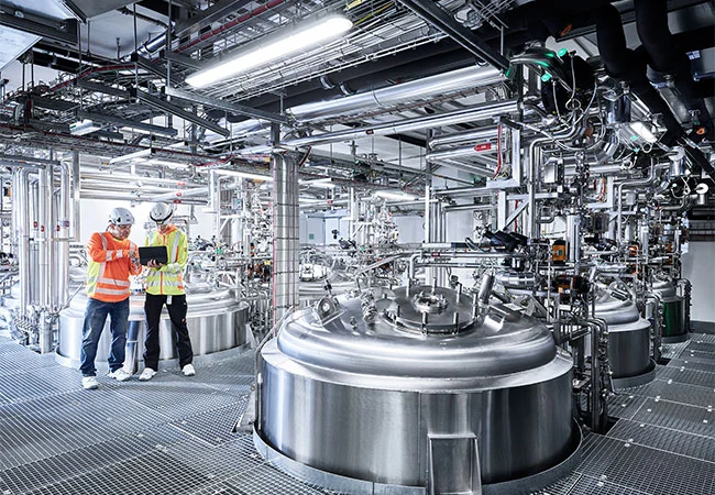 Zwei Männer schauen in einem Maschinenraum auf ein Tablet