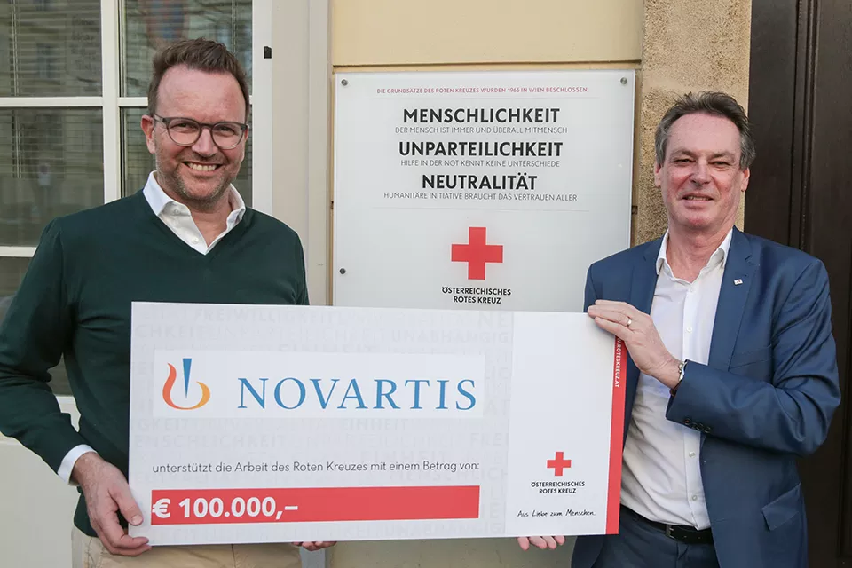 Michael Kocher, Country President Novartis Österreich, übergibt den Spendenscheck