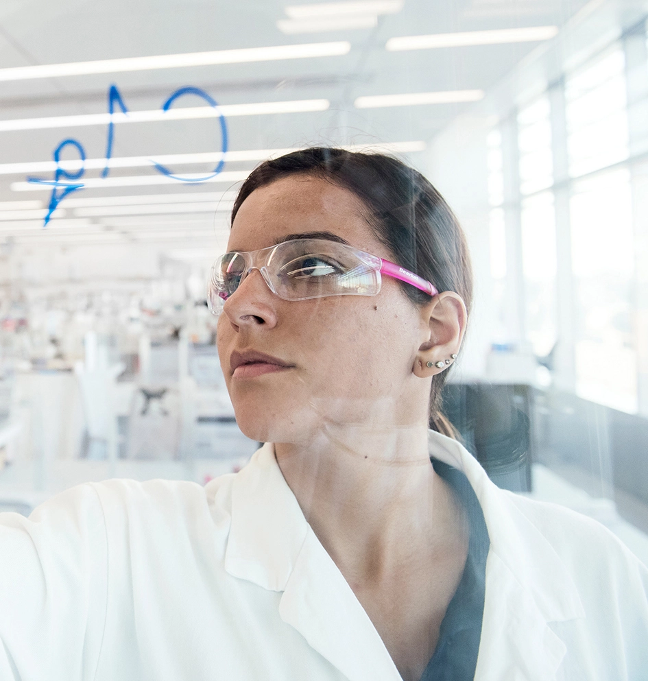 Un scientifique écrit sur un mur de verre