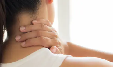 Vrouw voelt aan haar nek