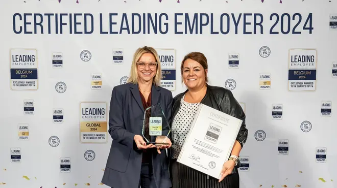 Two women with the award of Leading Employer 2024