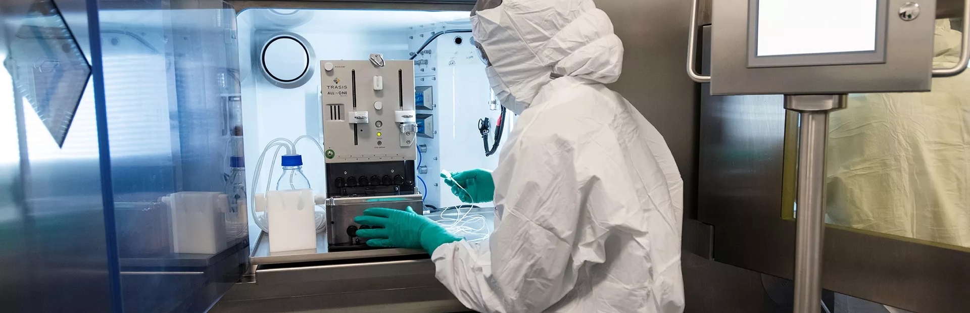 Een medewerker in volledige beschermingsuitrusting die gespecialiseerde apparatuur gebruikt op de RLT-productielijn 