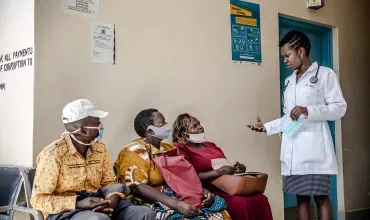 Медицински специалист дискутира с пациенти в Африка