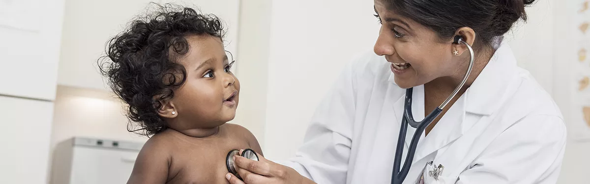 Médica examina batimento cardiáco de uma criança