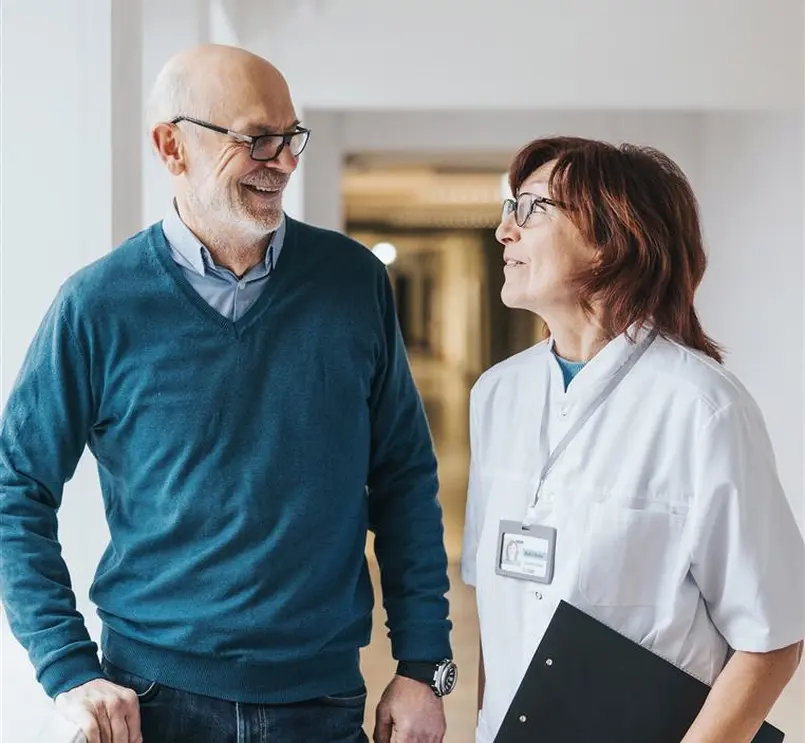 Deux personnes discutant dans un environnement médical.