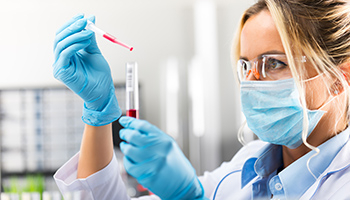 Une employée de laboratoire manipule une pipette et un tube à essais