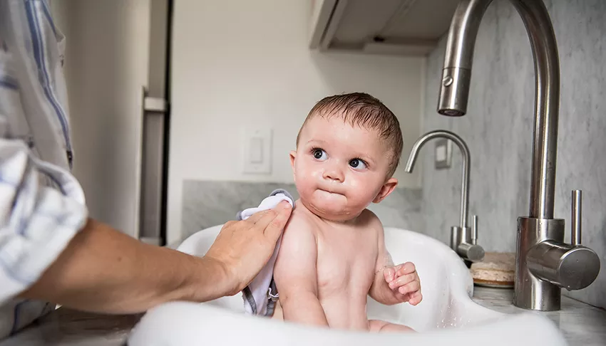 Un père fait prendre un bain à un bébé