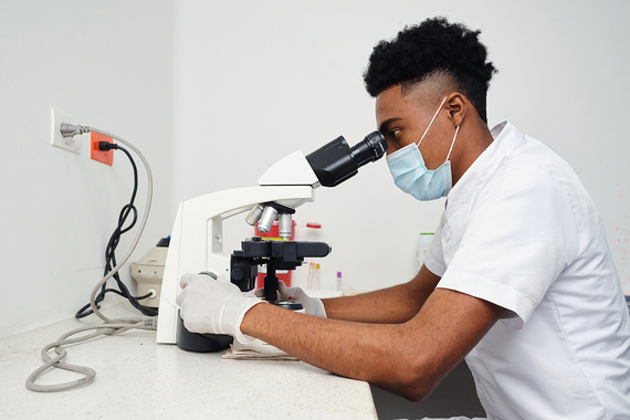Un technicien de laboratoire examine un échantillon au microscope