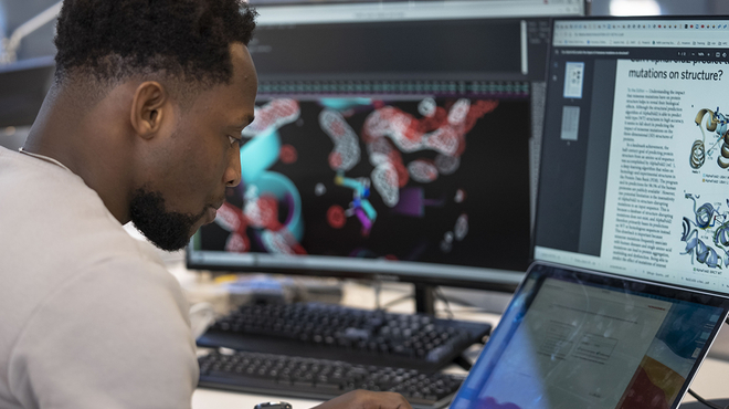 Un scientifique de Novartis est assis devant son ordinateur et construit des modèles virtuels pour le traitement du cancer Un scientifique de Novartis est assis devant son ordinateur et construit des modèles virtuels pour le traitement du cancer