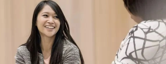 Žena s úsměvem s kolegyní na meetingu