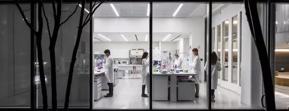 Scientists working In a lab at night seen by the outside of the building