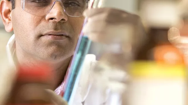 Scientist looking through test tube