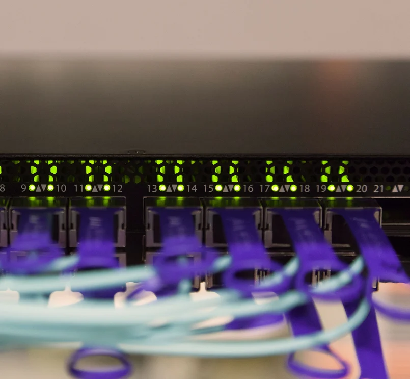 Glasfaserkabel, die mit einem Netzwerkswitch verbunden sind, mit LED-Anzeigen.