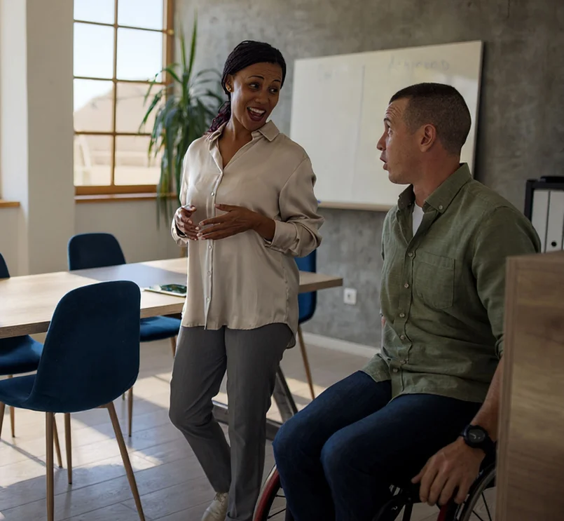 Zwei Personen im Gespräch in einem modernen Büro.