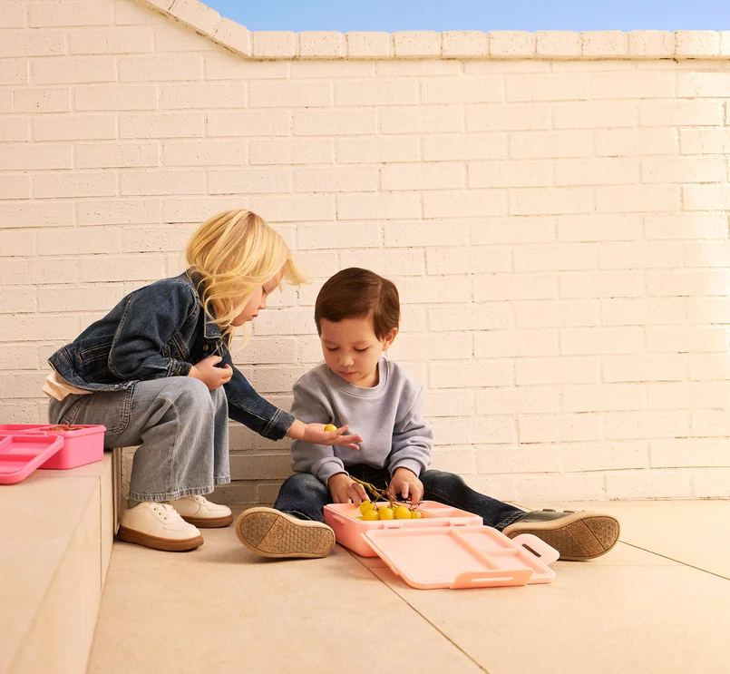 Kinder teilen Essen auf den Treppen.