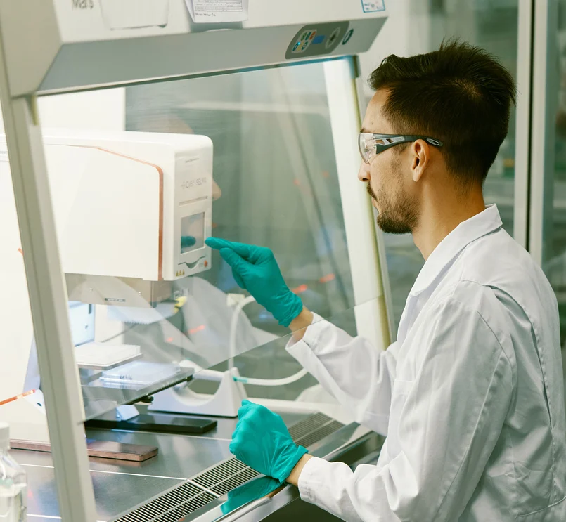 Wissenschaftler arbeiten im Labor mit Schutzkleidung.