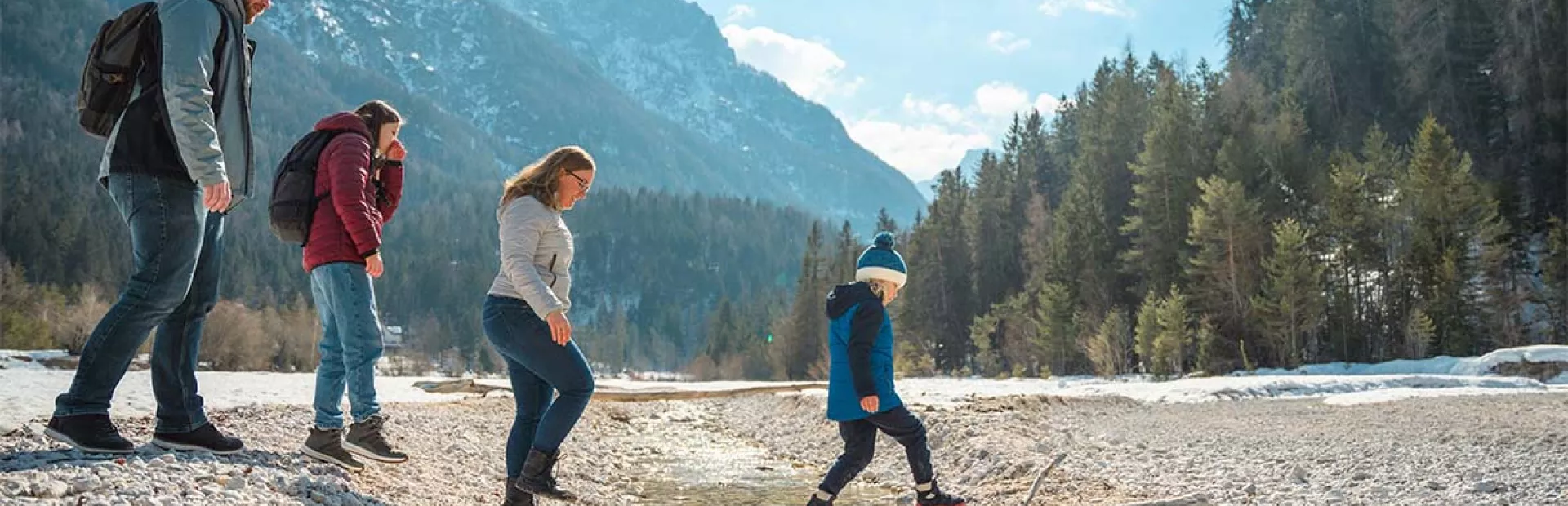 Familie überquert Bach in den Bergen
