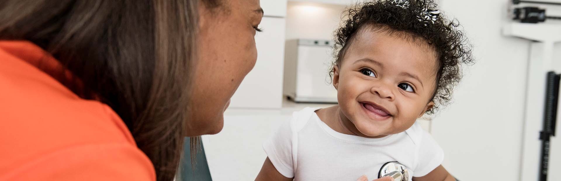 Ärztin hört den Herzschlag eines Babys ab