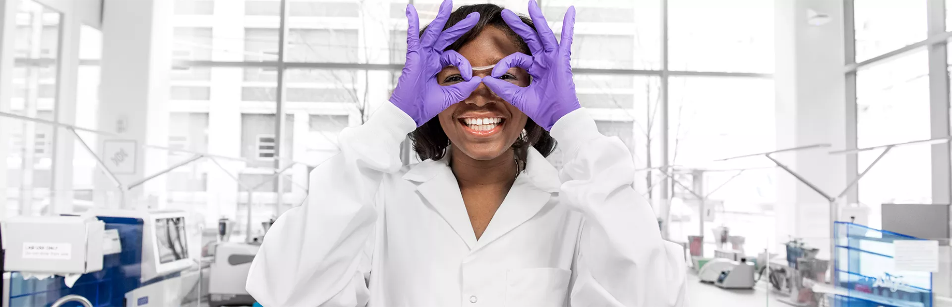 Wissenschaftlerin formt mit ihren Händen eine Brille
