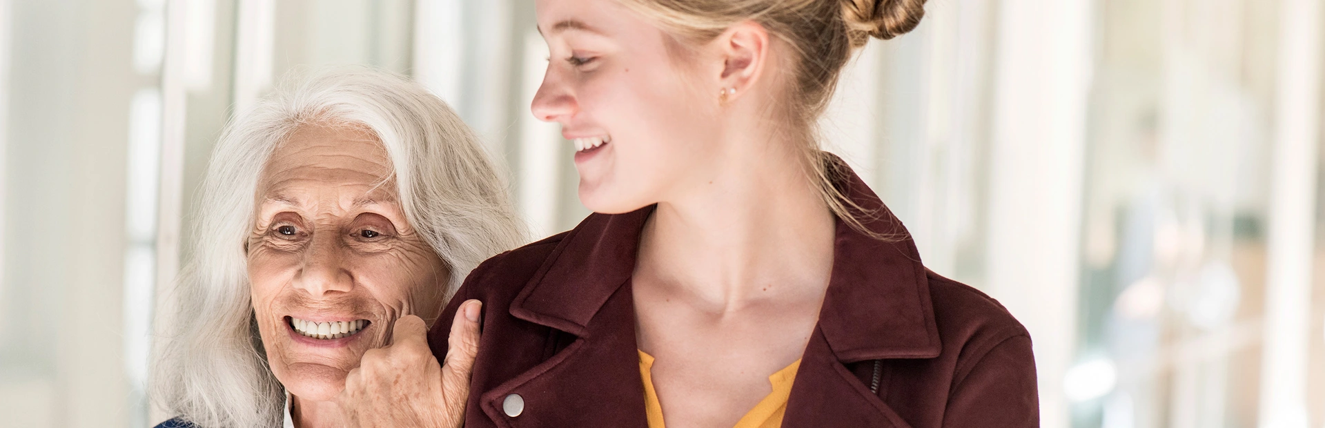 Eine ältere Frau hält sich am Arm einer jüngeren fest.
