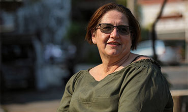 Person sitzt draußen im Sonnenlicht.