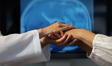 Handuntersuchung mit Gehirnscan im Hintergrund