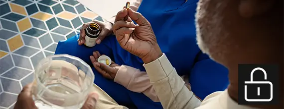 Medizinisches Fachpersonal verabreicht einem Patienten ein Medikament zum Einnehmen