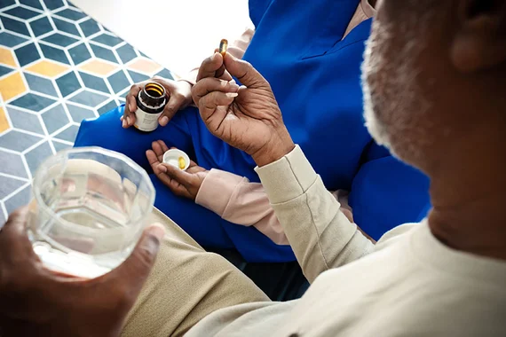 Eine Krankenschwester gibt einem Patienten Medikamente