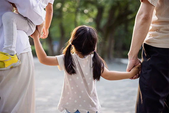 Familie hält Hand in Hand im Park.