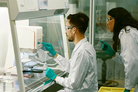 Wissenschaftler arbeiten im Labor mit Schutzkleidung.