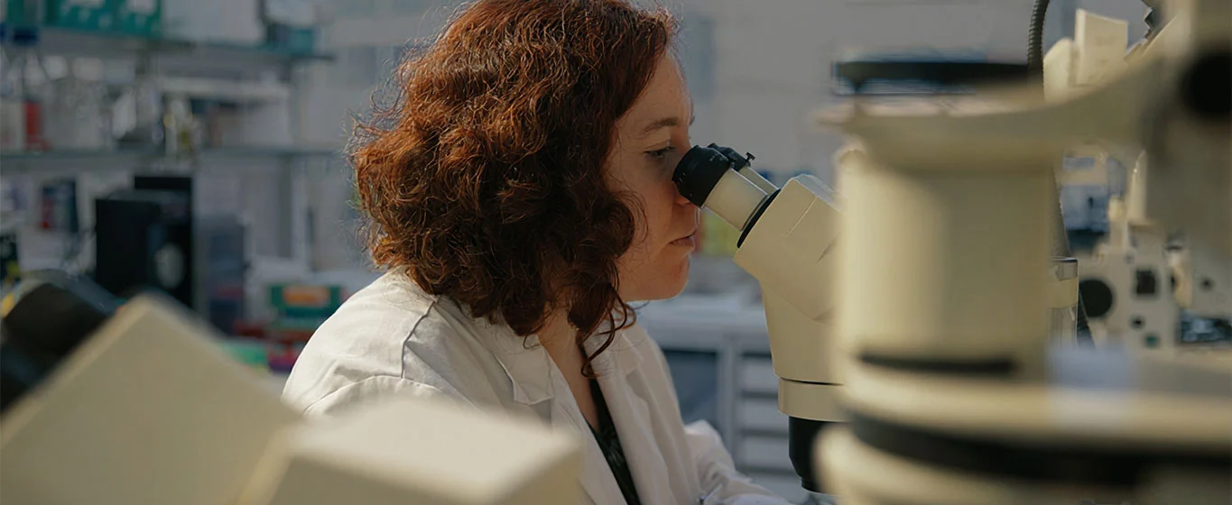 Wissenschaftlerin arbeitet mit einem Mikroskop im Labor