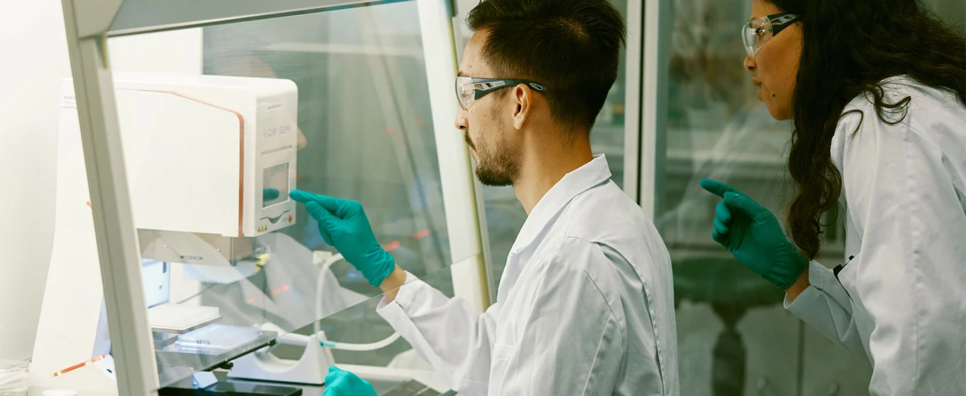 Wissenschaftler arbeiten im Labor mit Schutzkleidung.