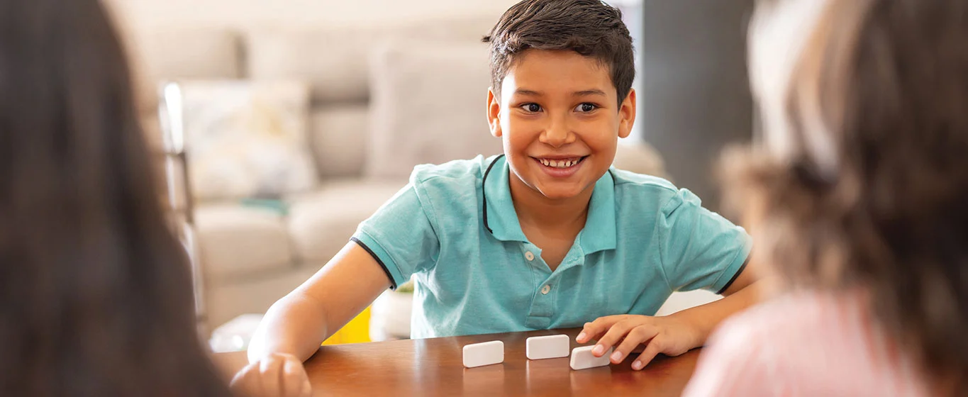 Kinder spielen Domino am Tisch
