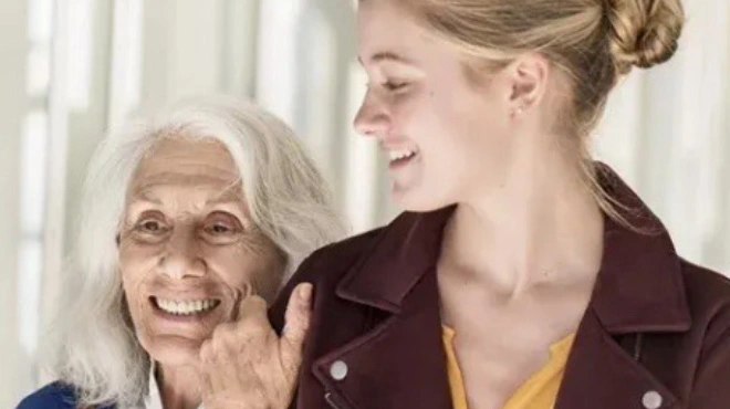 Eine ältere Frau hält sich am Arm einer jüngeren fest.