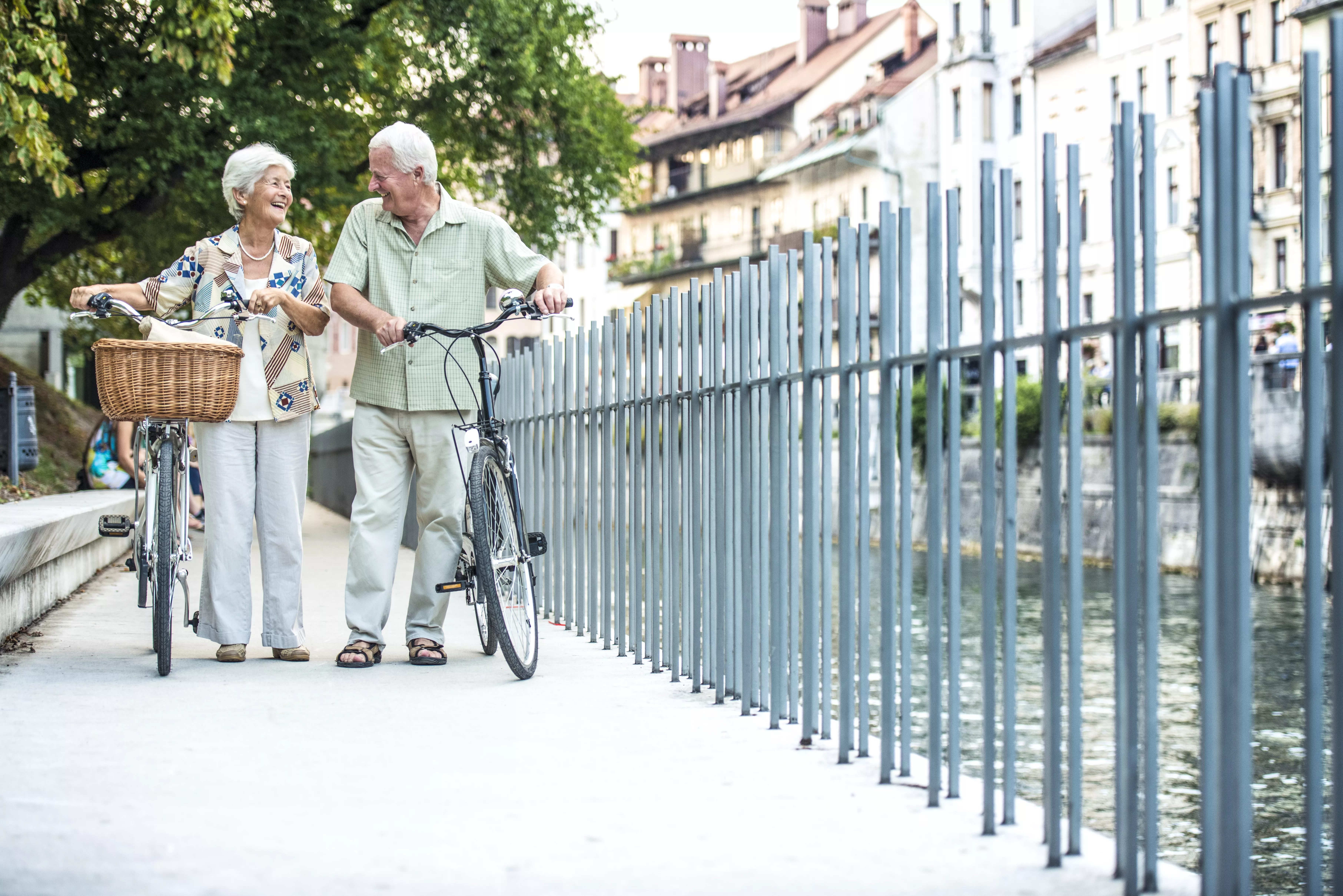 Ældre par går med deres cykler