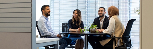 Four colleagues sitting around a table at the office