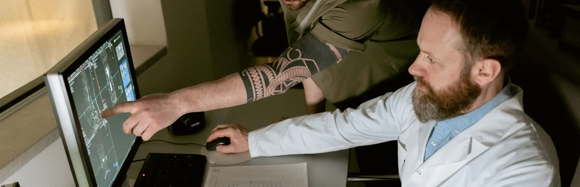 doctores señalando y consultando la pantalla de su ordenador