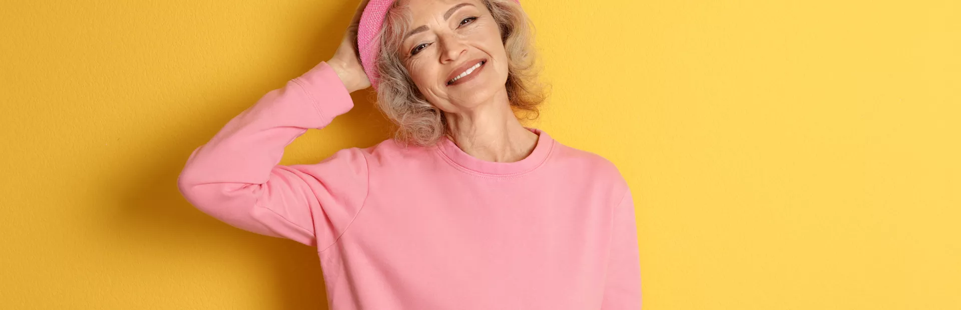 Mujer mayor sonriendo vestida de rosa