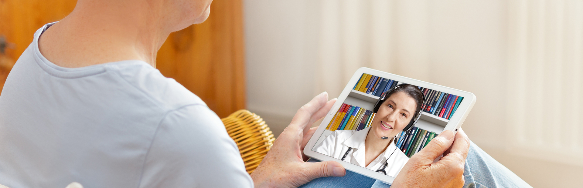 Mujer mayor atendiendo a una teleconsulta de su doctora a través de la tablet 