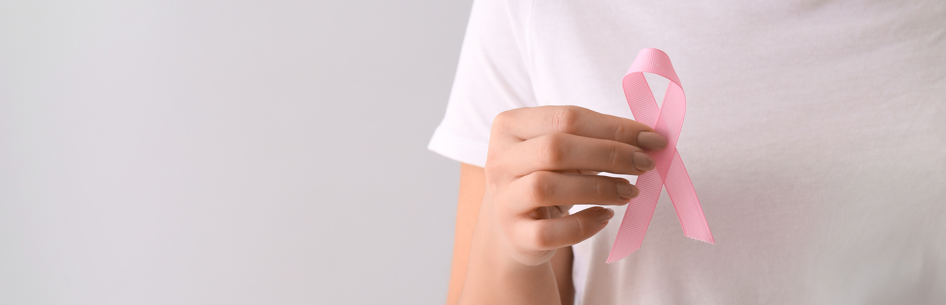 Mujer sujetando un lazo rosa